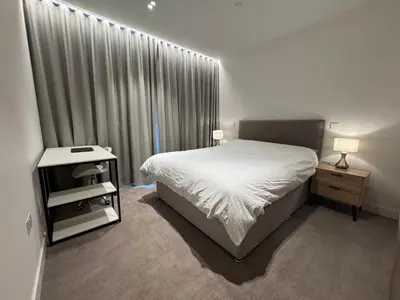 a bedroom with a white bed and a window with curtains at Modern Serviced Apartment in Kings Cross Central London in Moffat