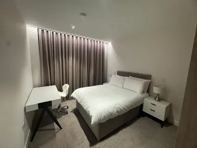 a bedroom with a bed and a desk and a window at Modern Serviced Apartment in Kings Cross Central London in Moffat