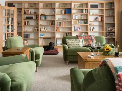 a living room with green chairs and a book shelf at Richmond, Tithebarn St, Keswick in Keswick