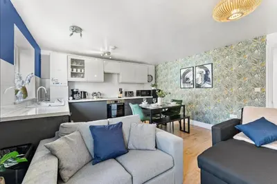a living room with a couch and a kitchen at Modern 2-Bed Apartment in Canterbury City Centre in Moffat