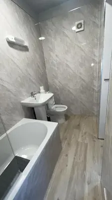 a bathroom with a sink and a toilet and a bath tub at QueensBerry accommodation in Annan