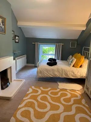 a bedroom with a bed and a fireplace at 1 Laithes Cottages in Skelton
