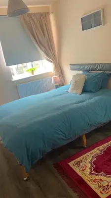 a bedroom with a blue bed with a window at QueensBerry accommodation in Annan