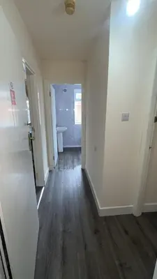 a hallway of a house with white walls and wood floors at QueensBerry accommodation in Annan