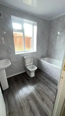a bathroom with a toilet and a tub and a sink at QueensBerry accommodation in Annan