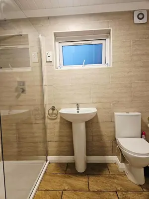 a bathroom with a sink and a toilet and a shower at Egremont 2-Bed Flat Near Lake District with Free Parking & Wi-Fi in Egremont