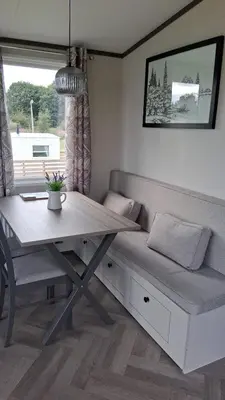 a table and a bench with a table and a table and a window at Three Lochs Holiday Park- Lochwood Caravan in Newton Stewart