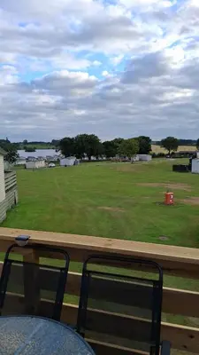 a view of a large field from a window at Three Lochs Holiday Park- Lochwood Caravan in Newton Stewart