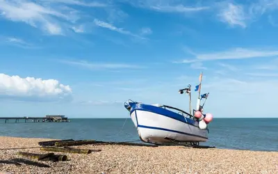 a blue and white boat sitting on the beach at St Mary's House by Keepers Cottages in Moffat
