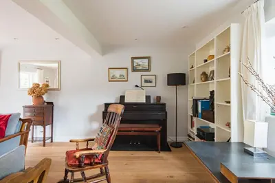 a living room with a piano and a table at St Mary's House by Keepers Cottages in Moffat