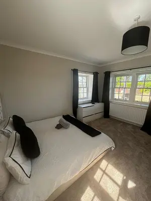 a bedroom with a white bed and two windows at Brig o Doon 3 in Ayr