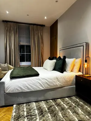 a bedroom with a large white bed with pillows at The Victorian Residence in Moffat