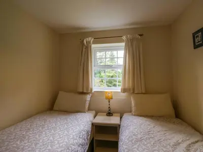 a bedroom with two beds and a window at Buckbarrow in Seascale
