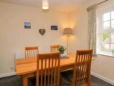 a dining room with a wooden table and chairs at Buckbarrow in Seascale