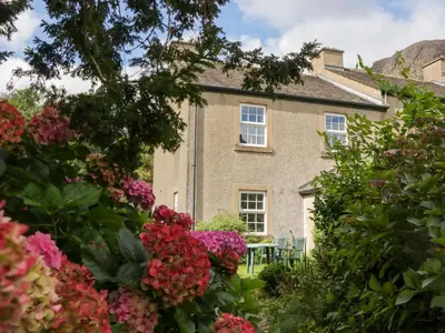 a house with flowers in front of it at Buckbarrow in Seascale