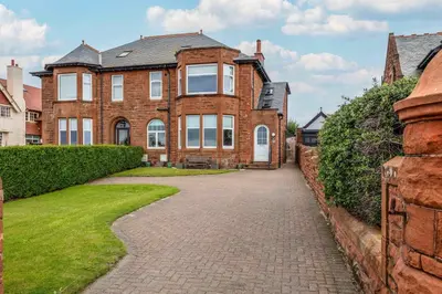 a brick house with a walkway in front of it at The Bay Suite - Donnini Apartments in Troon