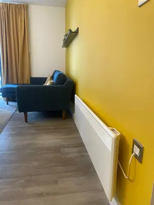 a living room with a blue couch and a yellow wall at The Bank Tower in Moffat