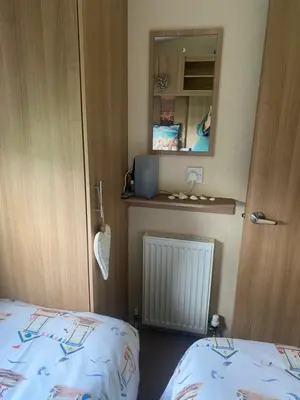 a small room with a bed and a mirror at Turnberry holiday park in Turnberry