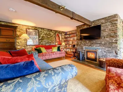a living room with a couch and a stone wall at 4 Bed in Cockermouth oc-sz098 in Lorton