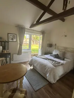 a bedroom with a bed and a table and a window at Hollyside Lodge in Carlisle