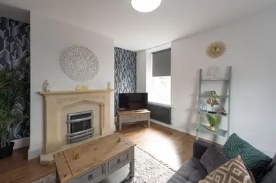 a living room with a fireplace and a tv at 5 Bed Workington House with Parking Near Station in Workington