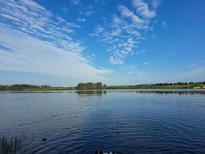 a large body of water with a blue sky and clouds at Three lochs holiday park Loch view 123 in Balminnoch