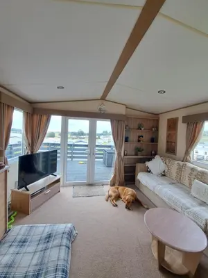 a dog laying on the floor in a living room at Three lochs holiday park Loch view 123 in Balminnoch