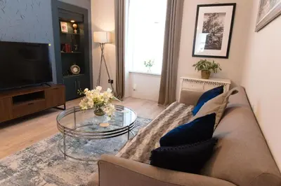 a living room with a couch and a glass table at Cosy 1-Bedroom Flat, Walk to Beaches in Troon