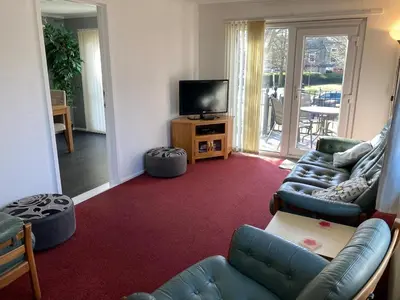 a living room with a couch and a tv at Blackpool chalet - free parking in Moffat