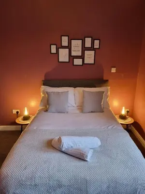a bedroom with a bed with pictures on the wall at No3 Spacious Apartment Cockermouth in Cockermouth