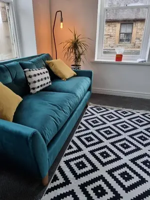 a blue couch in a living room with a rug at No3 Spacious Apartment Cockermouth in Cockermouth