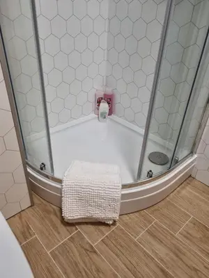 a shower with a white tub with a towel on the floor at No3 Spacious Apartment Cockermouth in Cockermouth