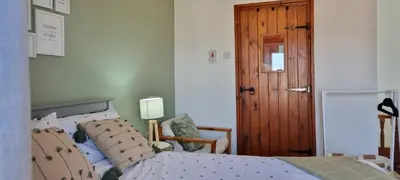 a bedroom with a bed and a wooden door at The Creamery High Harrington in Harrington