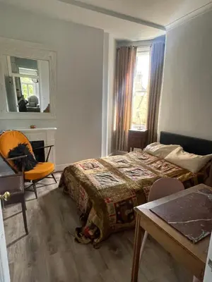 a bedroom with a bed and a desk and a window at Bright peaceful room 4th floor in front Battersea park in Moffat
