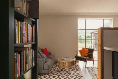 a living room with a book shelf filled with books at Swallow Barn at Greenclose Farm in Penrith