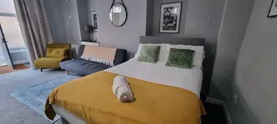a bedroom with a large bed with a yellow blanket at Studio No1, Cockermouth, The Lakes in Cockermouth