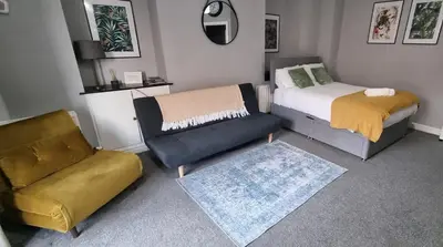 a bedroom with a bed and a couch and a chair at Studio No1, Cockermouth, The Lakes in Cockermouth