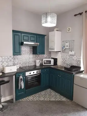 a kitchen with green cabinets and white appliances at Studio No1, Cockermouth, The Lakes in Cockermouth