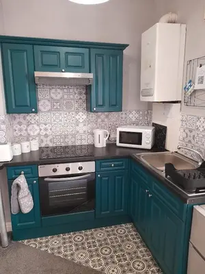 a kitchen with green cabinets and a sink at Studio No1, Cockermouth, The Lakes in Cockermouth