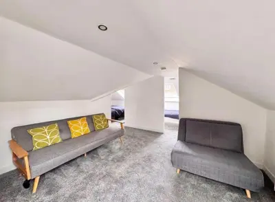 a living room with a couch and two chairs at Central Charming Sea View Loft Flat in Troon