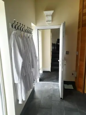 a room with a rack of white shirts on a wall at Kirkcudbright Holiday Apartments - Apartment B in Kirkcudbright
