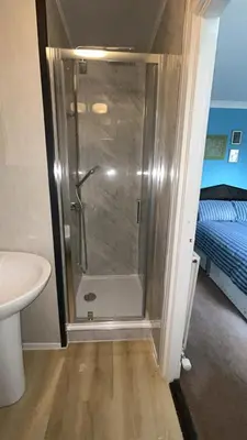 a shower in a bathroom with a toilet and a sink at QueensBerry Annan in Annan