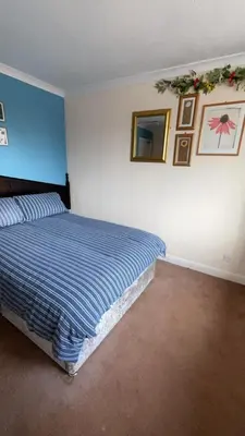 a bedroom with a bed and a mirror on the wall at QueensBerry Annan in Annan