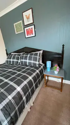 a bedroom with a bed and a table at QueensBerry Annan in Annan