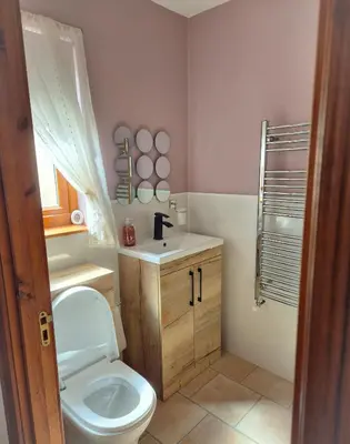 a bathroom with a toilet and a sink at The Yard Bungalow in Sanquhar