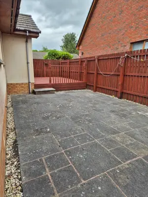 a patio with a wooden fence and a house at The Yard Bungalow in Sanquhar