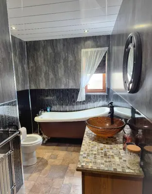a bathroom with a tub and a toilet and a sink at The Yard Bungalow in Sanquhar
