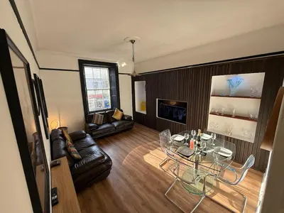 a living room with a couch and a glass table at 3 bedroom traditional apartment in Ayr