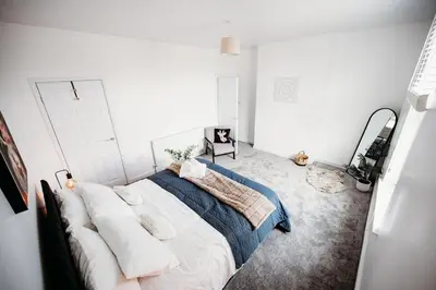 a bedroom with a large bed in a white room at 4 Bed Sheffield home in Moffat