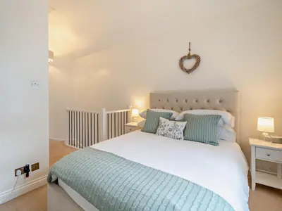 a bedroom with a large white bed with blue pillows at 1 Bed in Keswick 96314 in Keswick